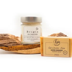 Savon Surgras Artisanal et bougie parfumée posés sur un décor en bois