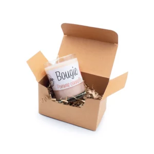Coffret bougie de noël en boîte kraft ouverte avec une bougie parfumée pomme cannelle