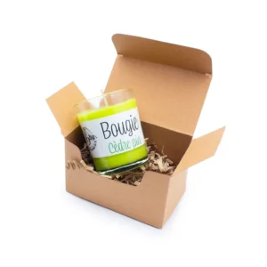 Coffret bougie de noël en boîte kraft ouverte avec une bougie parfumée cèdre et pin